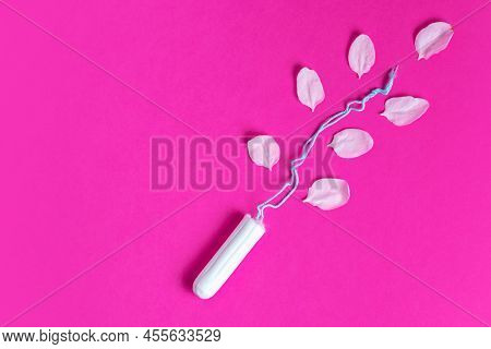 Female Tampon With With Cherry Petals On A Pink Background. Hygienic White Tampon For Women. Cotton 
