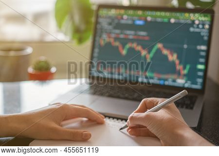 Female Hands Writing Down Numbers From Laptop. Investment Analysis, Trading Concept. Technology, Dig