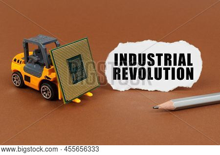 Technological Concept. On A Brown Surface, A Forklift Is Transporting A Processor, Next To It Is Pap