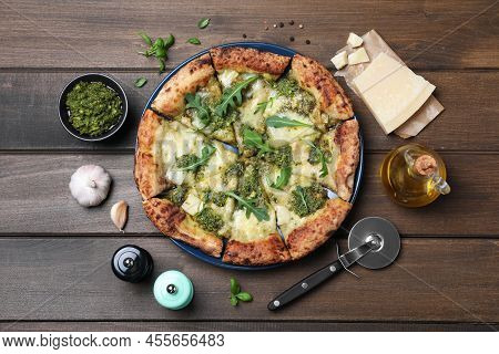 Delicious Pizza With Pesto, Cheese And Arugula Served On Wooden Table, Flat Lay