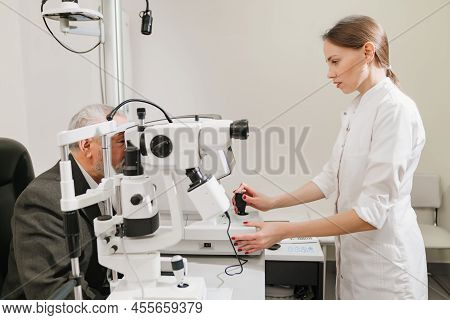 Doctor Examines Elderly Mans Eye On Screen Of Autorefractometer.
