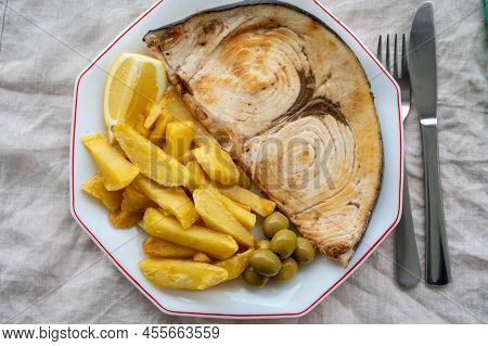 Seafood Dish, Grilled Steak From Swordfish Or Spada Served With French Fried Potatoes And Green Oliv