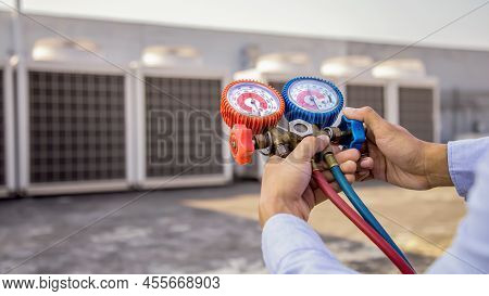 Close Up Hand Of Air Repairman Using Manifold Gauge Is Measuring Equipment For Checking Refrigerant 