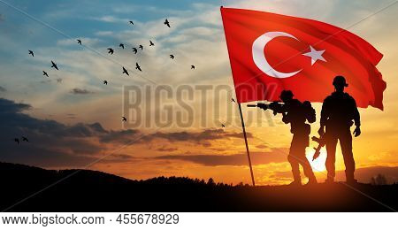 Silhouettes Of Soldiers With Turkey Flag On Background Of Sunset. Concept Of Crisis Of War And Polit