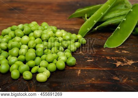 Fresh Peeled Green Pease On A Brown Wooden Table With Copy Space. Fresh Pods Of Green Peas Horizonta