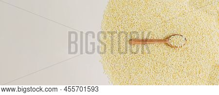 Banner. Raw Risoni Pasta With A Sprig Of Rosemary And A Wooden Spoon On A Light Background. The Conc