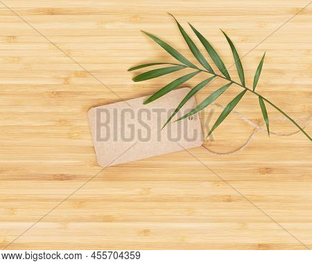 Empty Craft Label With Palm Leaf On A Wooden Background. Eco Friendly Background With Label For Your