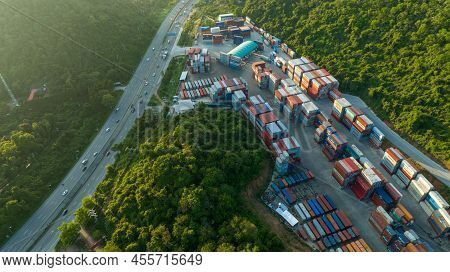 The Cargo Container Yard Next The Road And Surrounded By Mountains , Forklift Truck And Cargo At Dep