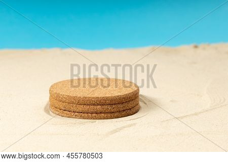 A Round Pedestal Is Set On The Sand, An Empty Pedestal. Yellow Sand And Blue Background