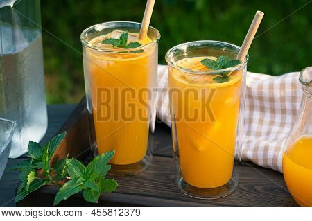 Refreshing Summer Homemade Orange Cocktail In Tall Double Glass Glasses With Mint And Ice, Selective