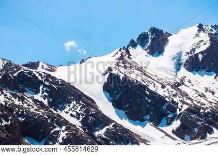 Rocky Fathomed Mountain Under The Sun. And Blue Skies
