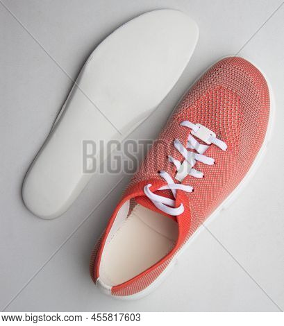 Orange Sport Shoes With Orthopedic Insoles On Neutral Background.. Top View.