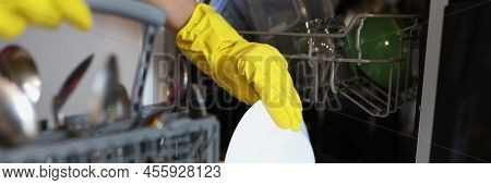 Close-up Of Woman Loading Dishwasher, Open Dishwasher With Clean Plates After Washing. Modern Kitche