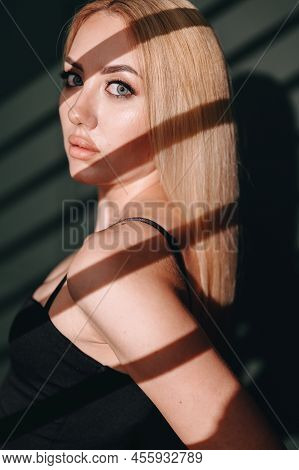 Close-up Portrait Of A Hard Light Blonde Against A Dark Background. The Concept Of Self-confidence. 
