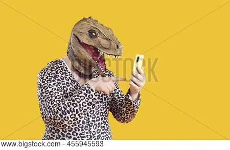 Ecentric Funny Fat Man In Dinosaur Mask Uses Mobile Applications And Communicates On Social Networks