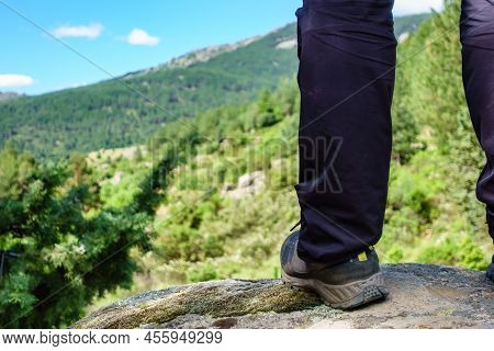 Foot Of A Man Climbing A Rock And Seeing The Mountain Landscape.