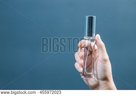 Young Woman Spraying Perfume On Blue Background, Closeup