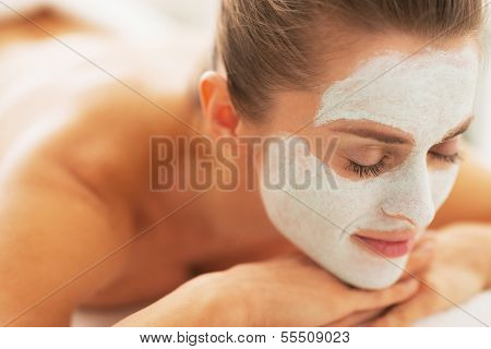 Relaxed Young Woman With Revitalising Mask On Face Laying On Mas