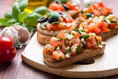Italian Appetizer Bruschetta with roasted tomatoes, mozzarella cheese, garlic and herbs 