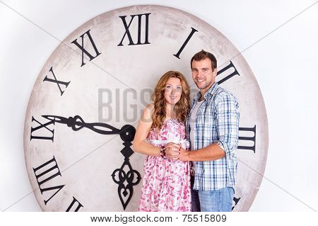 Happy Pregnant Couple on white background with giant clock