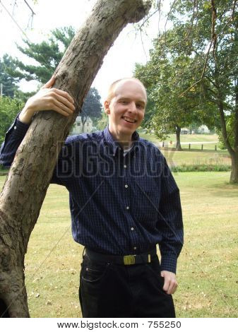 Hombre apoyado en el árbol