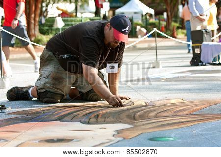 Chalk Artist Kneels And Draws Halloween Scene On Pavement