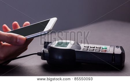 Man using smartphone to express pay against grey background