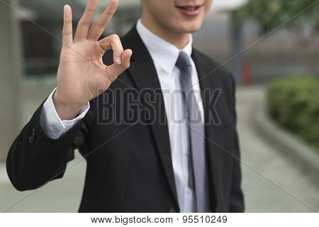 Asian business man give you an okay gesture.