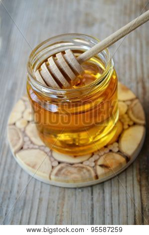 Golden honey with honeystick. cinnamon and anise stars on wooden table