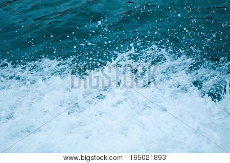 Water splashing. Crystal clear sea water beating against the boat.