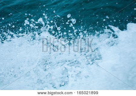 Water splashing. Crystal clear sea water beating against the boat.