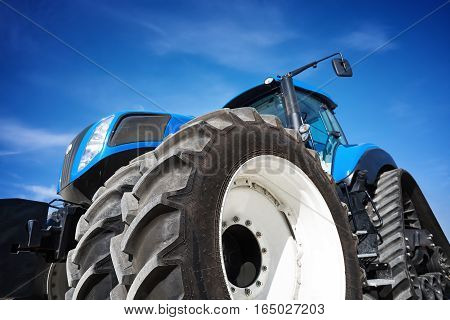 Tractor working on the farm, a modern agricultural transport, a farmer working in the field, tractor on sky background, modern tractor closeup