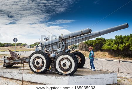 Little boy looking at the Second World War coastal defence howitzer on Robben Island