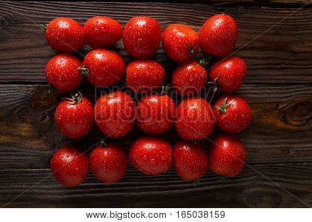 Red tomatoes with water drops. Tomatoes of different varieties. omatoes background. Fresh tomatoes Healthy food concept. Colorful festive still life. Loosely laid tomatoes in different positions.