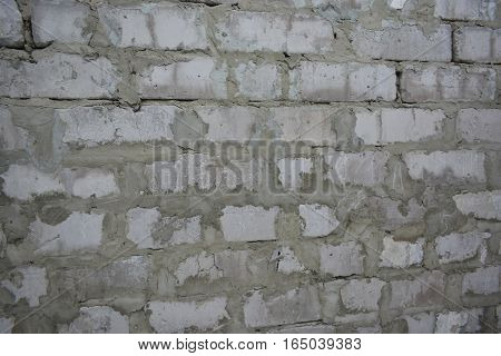 brick wall built by human hands of white brick and cement mortar