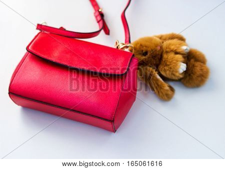 Red ladies handbag ladies handbag with a soft toy.