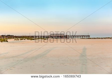 romantic sunset at the ebach with wooden pier at Dauphine Island