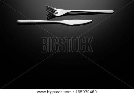 Black food background. Stainless steel, modern silverware on black background with reflection. Image with copy space. Symbol or concept for diners, cafes and good food competitions and festivals