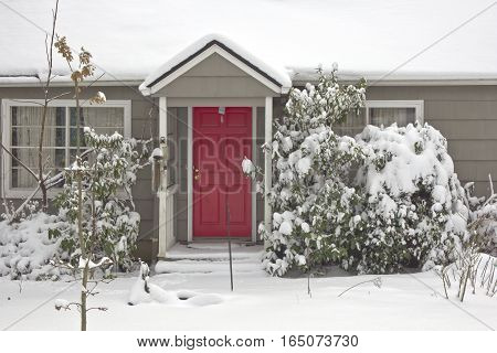 Red door and snow covered house Gresham Oregon.