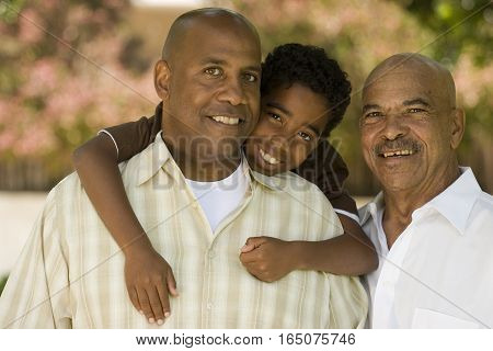 Grandfather with his adult son and grandchild at the park.