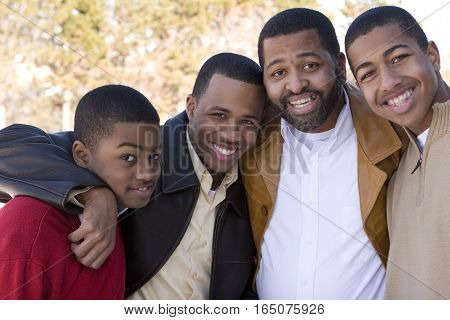 Happy African American father and his teenage sons.