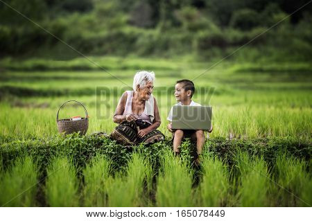 Happy boy and grandmother using laptop asia thailand.