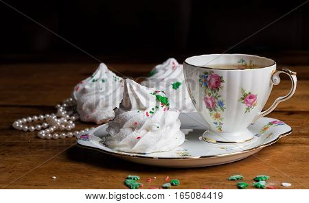 refined porcelain cup of tea and sauser with zephyr meringue marshmallow wood pearls