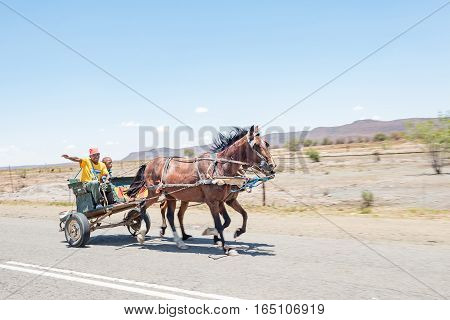 FAURESMITH SOUTH AFRICA - DECEMBER 31 2016: A friendly driver and companion on a horse drawn carriage in Fauresmith a small town in the Free State Province