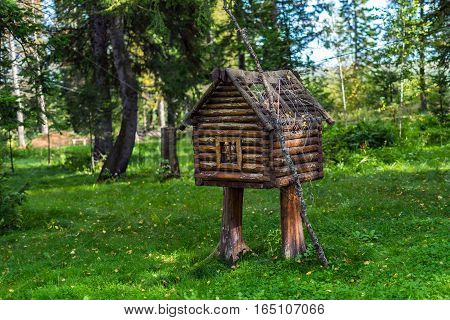The wooden hut on legs. Fabulous a little house in the woods. Wooden decorative house lawn ornament