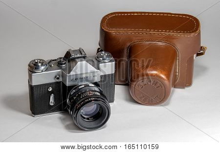 Gatchina, Russia - January 14, 2017: The old Soviet film camera Zenit. Photographed on a bright background. To the right of the camera is its leather case.