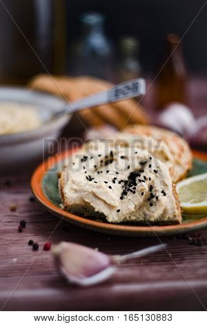 Sandwiches with hummus on the wooden board.