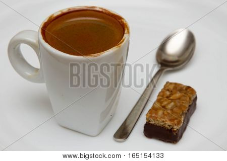 cup of hot espresso and candy on a white background,