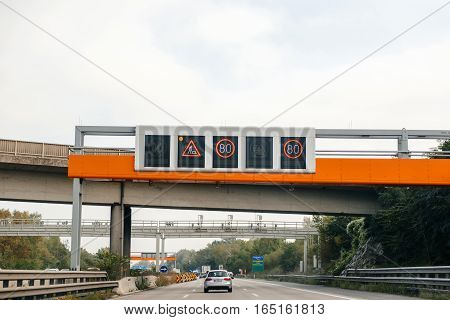 VIENNA AUSTRIA - SEP 30 2014: Driver POV point of view of electronic highway overhead Slow down sign due to construction works on Austrian autobahn