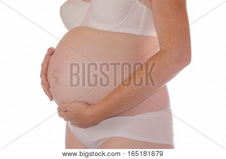 Mature pregnant woman tenderly hugging her belly